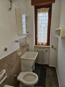 een badkamer met een wit toilet en een raam bij Villa Avucat in San Marco Argentano