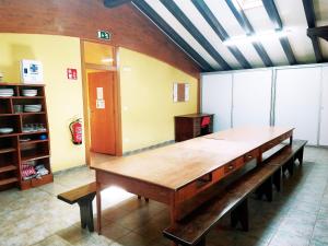 Amaiurko Aterpea في Maya del Baztán: طاولة خشبية كبيرة في غرفة مع مقاعد