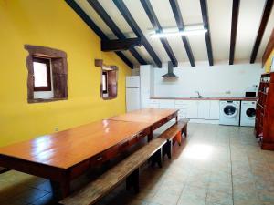 een keuken met een lange houten tafel in een kamer bij Amaiurko Aterpea in Maya del Baztán