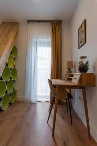 Zimmer mit einem Schreibtisch, einem Fenster und einem Tisch mit einem Laptop. in der Unterkunft Fabrica Apartments 13 in Cluj-Napoca