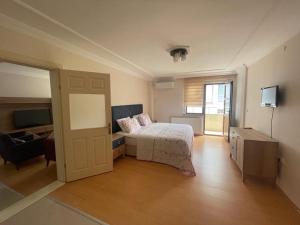 1 dormitorio con 1 cama, TV y puerta en Akustik Residence en Bostancı