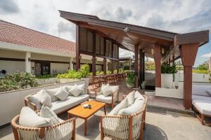 an outdoor patio with couches and tables and chairs at Sedasa Lodge in Canggu