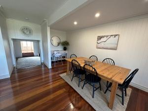 a dining room with a wooden table and chairs at Bells Beach Bungalow in Clontarf