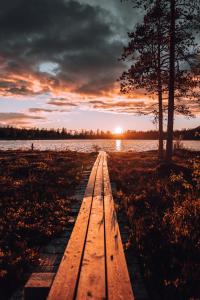 a wooden pathway leading to a lake at sunset at Idre Himmelfjäll Resort in Idre