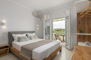 a bedroom with a large bed and a balcony at Konstantinos in Adamantas