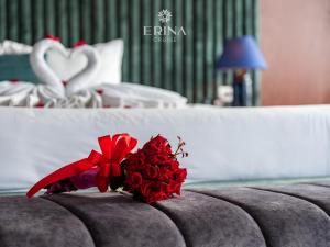 un ramo de rosas rojas sentado en la parte superior de una cama en Erina Cruise, en Ha Long