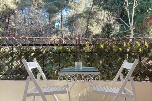 2 Stühle und ein Tisch auf der Terrasse in der Unterkunft Forest Apartment Salonica in Thessaloniki