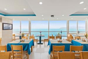 a restaurant with tables and chairs and a view of the ocean at Blue Pearl Hotel in Nha Trang