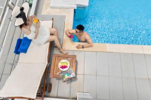 un hombre y una mujer sentados en una piscina en Blue Pearl Hotel, en Nha Trang