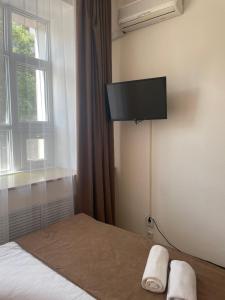a bedroom with a bed with a flat screen tv on the wall at Belon Land in Astana
