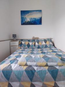 - un lit avec une couette et des oreillers colorés dans l'établissement Apartment Sunset, à Senj