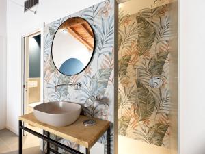 een badkamer met een wastafel en een spiegel bij SG9 CITY APARTMENTS in Brescia