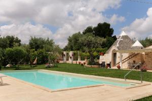 a swimming pool in a yard with a stone building at Trullo Rinaldi - Private Pool and Sauna in Castellana Grotte