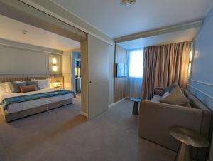 um quarto de hotel com uma cama e um sofá em Hotel Bavaria Blu em Mamaia