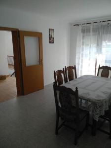 een eetkamer met een tafel en stoelen en een deur bij Apartman Vidaković in Bilje