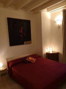 een slaapkamer met een rood bed en een schilderij aan de muur bij Da Cinema a Residenza d'Artista BLUE YELLOW RED in Orbetello
