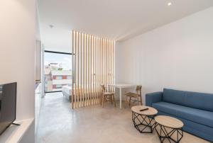 uma sala de estar com um sofá azul e uma mesa em Stayaday Apartments Albufera em Madri