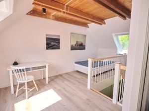 a room with a crib and a desk and a bed at Vinkelgaard in Ringsted
