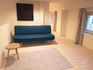 een blauwe bank in een woonkamer met een tafel bij Da Cinema a Residenza d'Artista BLUE YELLOW RED in Orbetello