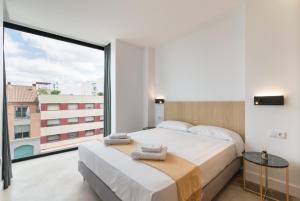 a bedroom with a large bed and a large window at Stayaday Apartments Albufera in Madrid