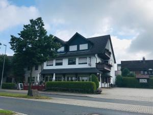 a large white house with a black roof at Gasthof zur Post Hotel - Restaurant in Breckerfeld