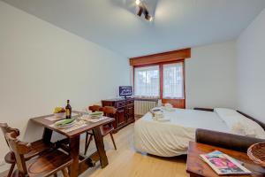 a living room with a bed and a table and a couch at Studio Genzianella Ski In-Ski Out 100m - Happy Rentals in Sestriere