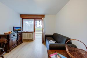a living room with a couch and a television at Studio Genzianella Ski In-Ski Out 100m - Happy Rentals in Sestriere