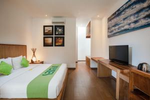 a bedroom with a large bed and a flat screen tv at Sedasa Lodge in Canggu +34 photos