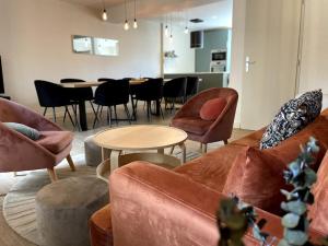 Una sala de estar con un sofá y sillas y una mesa. en Maison Flore, en Besançon