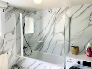 y baño con ducha y paredes de mármol blanco. en Maison Flore, en Besançon 31 fotos más