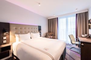een hotelkamer met een groot bed en een bureau bij Premier Inn Leipzig City Oper in Leipzig