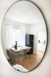 a mirror reflecting a table and chairs in a kitchen at Studio-Joki - Valoisa asunto keskustassa in Turku