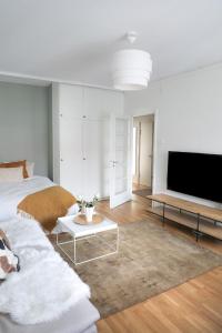 a living room with two beds and a tv at Studio-Joki - Valoisa asunto keskustassa in Turku