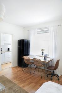 a dining room with a table and chairs and a black refrigerator at Studio-Joki - Valoisa asunto keskustassa in Turku