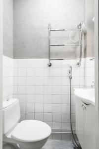 a white bathroom with a toilet and a sink at Studio-Joki - Valoisa asunto keskustassa in Turku