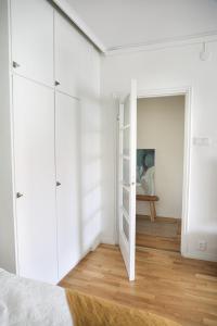 a bedroom with white cabinets and a door to a room at Studio-Joki - Valoisa asunto keskustassa in Turku