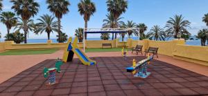um parque infantil com um escorrega e um baloiço em Magnificas vistas al mar em Oropesa del Mar