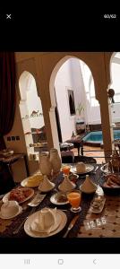 une table avec des assiettes et des bols de nourriture dans l'établissement Riad Des ours, à Marrakech