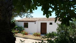 a white house with flowers in front of it at Ambrosia casa vacanza " Giada " in Orosei