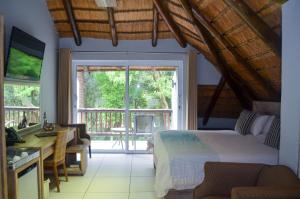 a bedroom with a bed and a sliding glass door at Highveld Splendour Boutique Bed and Breakfast in Ermelo