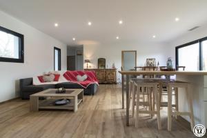 sala de estar con sofá y mesa en Villa jacuzzi, terrain de pétanque et aire de jeux vue sur les Pyrénées, en Seilhan