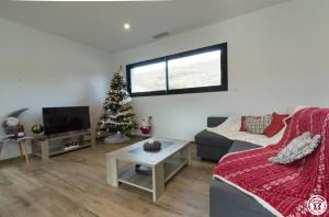 a living room with a christmas tree and a couch at Villa jacuzzi, terrain de pétanque et aire de jeux vue sur les Pyrénées in Seilhan