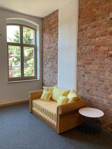 - un salon avec un canapé et un mur en briques dans l'établissement Nr9Marinehafen - Ferienwohnungen, à Stralsund