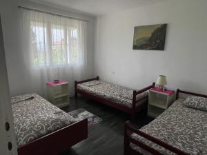 a room with three beds and a window at Apartments Matija in Sutomore