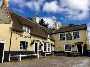 a building with a thatched roof with a picnic table at The Crown Inn Smallburgh in Smallburgh