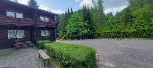 a building with a bench in a yard with trees at Penzion Svojanov in Svojanov