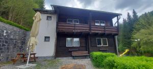 a wooden house with an umbrella and a playground at Penzion Svojanov in Svojanov