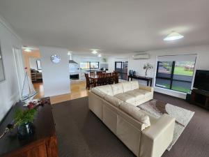 a living room with a white couch and a kitchen at Bayviews in Strahan