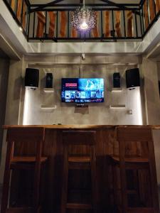 a bar with stools and a tv on a wall at Cabin in the Alley in Alfonso