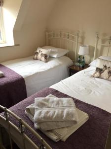 a bedroom with two beds with towels on them at The Crown Inn Smallburgh in Smallburgh